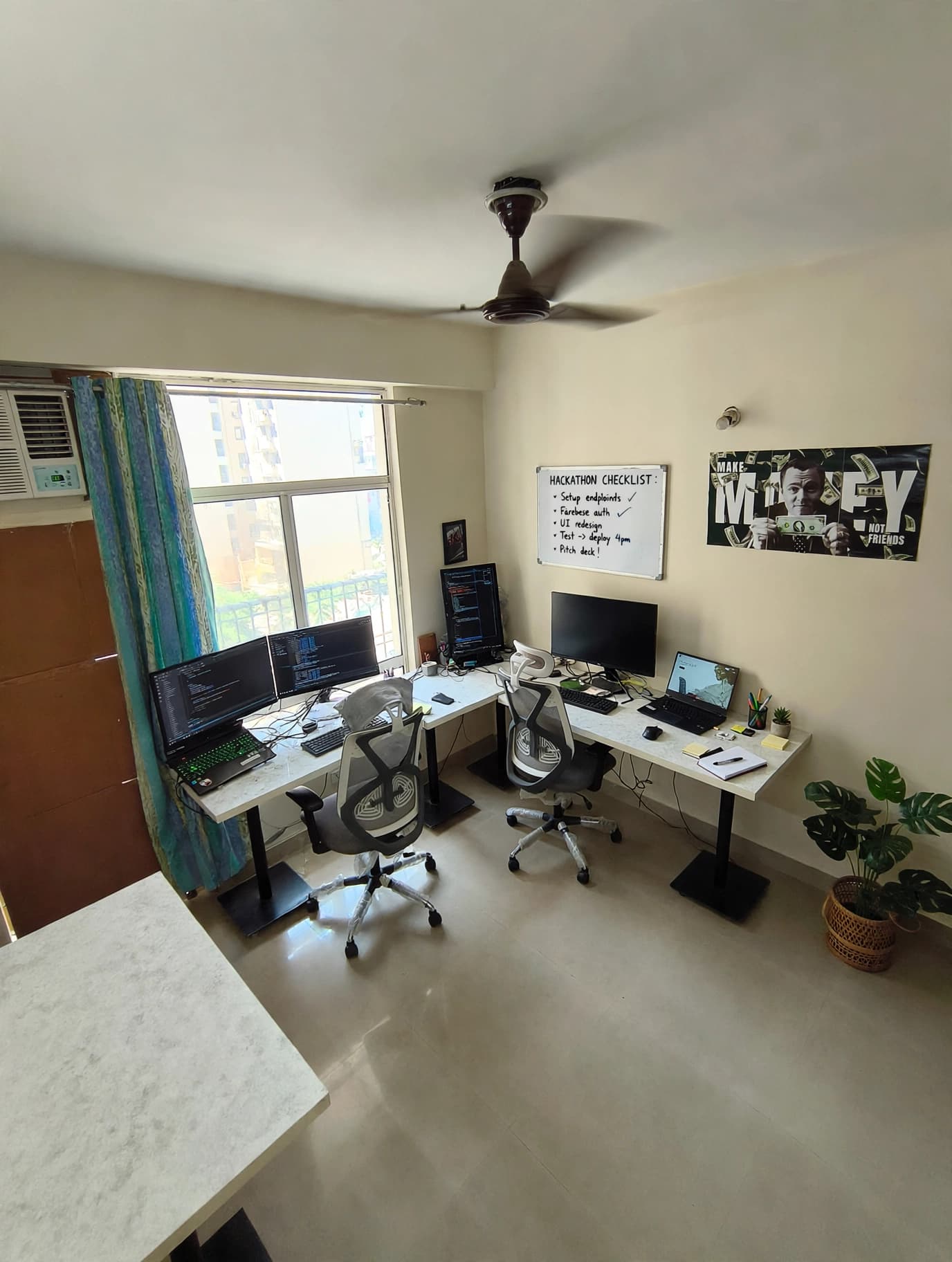 The Flat 605 workspace with development monitors and a hackathon planning board